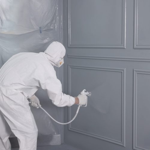 Decorator,Dyeing,Wall,In,Grey,Color,With,Spray,Paint,,Back